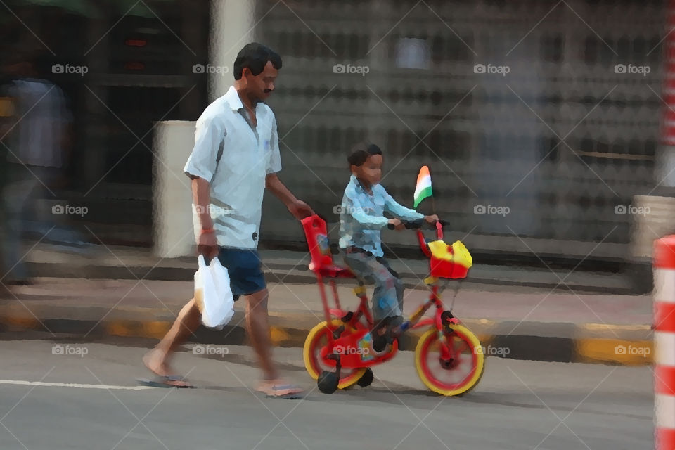 a man with is son teaching him cycle