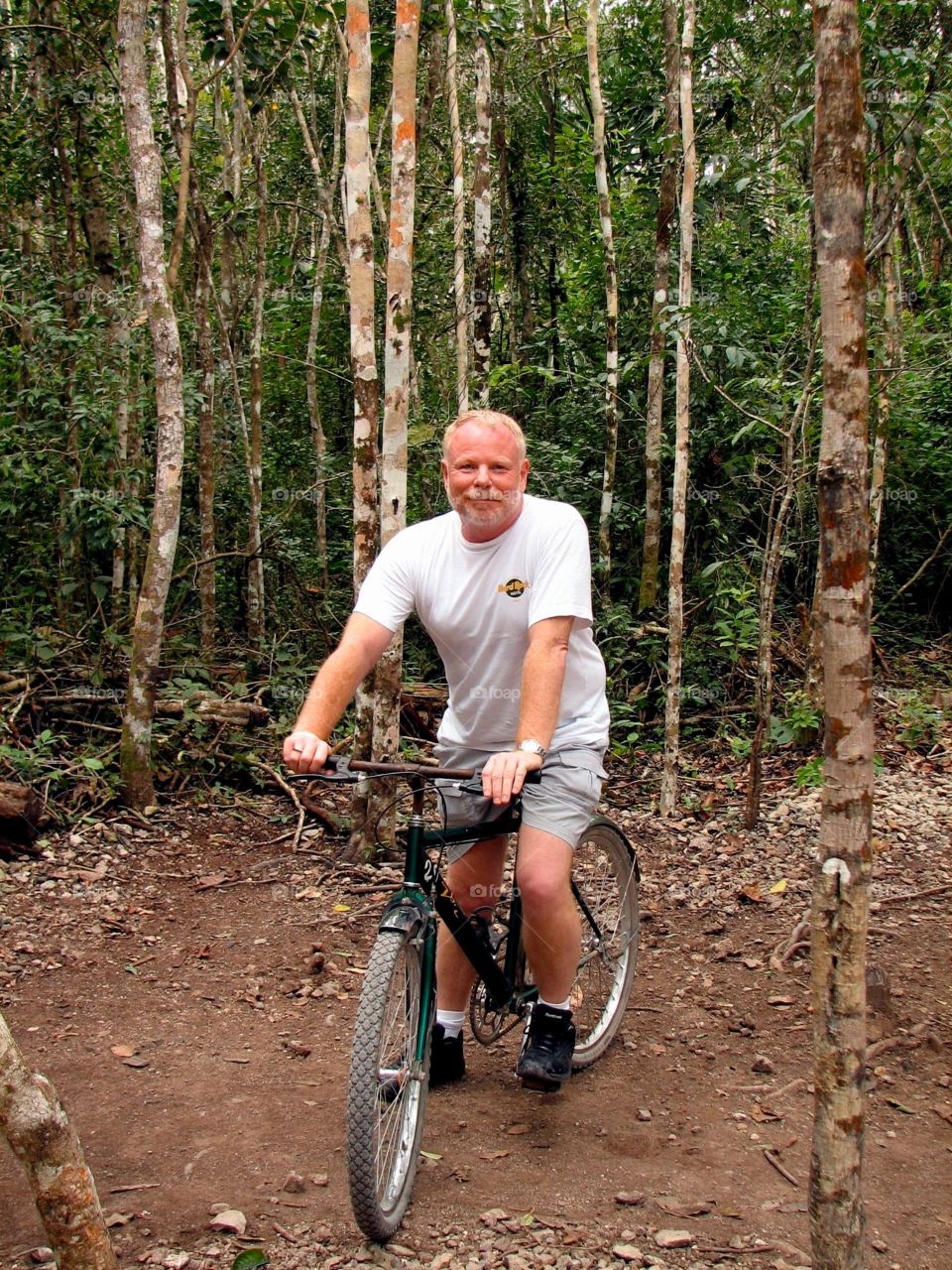 Fred on bike. Fred peddles through the woods to the ruins at Coba in Mexico