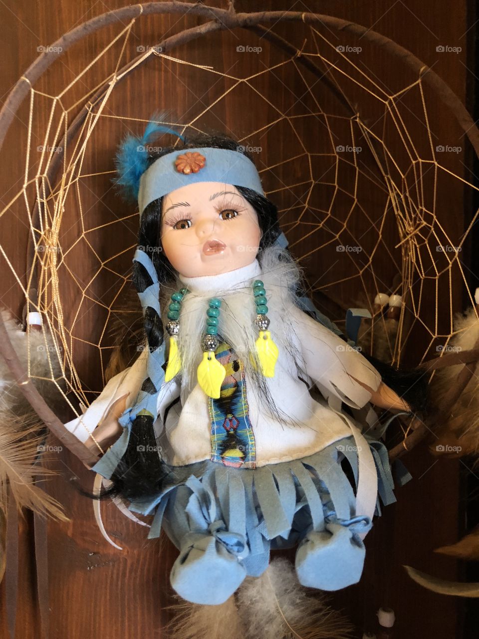 A Native American doll dressed with feathers and headgear. 