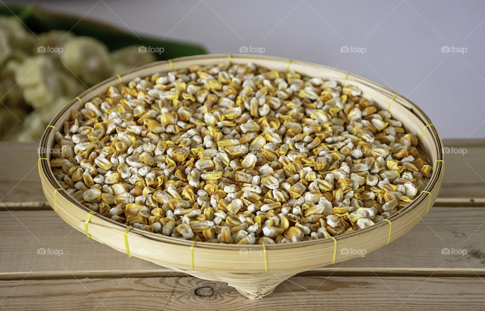 Seed corn in bamboo baskets on wooden table.