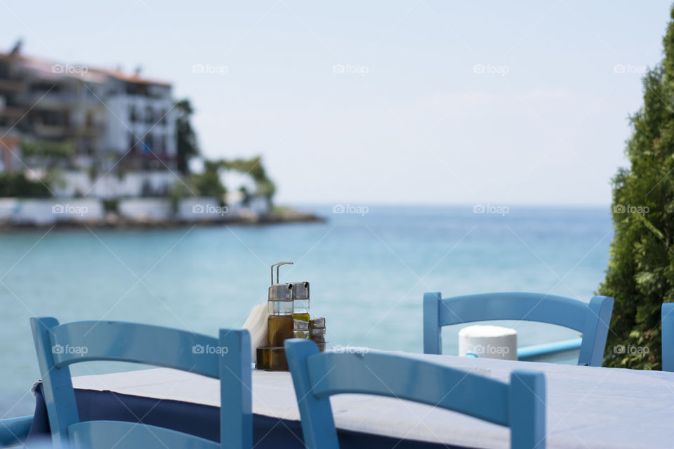 typical greek table. typical greek restaurant table set with sea in the background