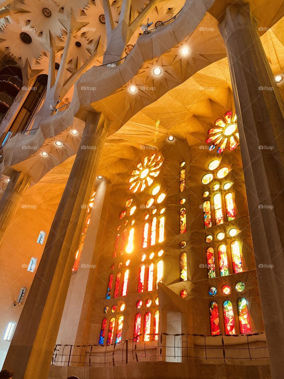 The golden light of the sun filters through the church's stained glass, creating a play of reflections and shadows that fills the space with sacred beauty. The rays seem to dance on the walls, imparting a sense of peace and spirituality.