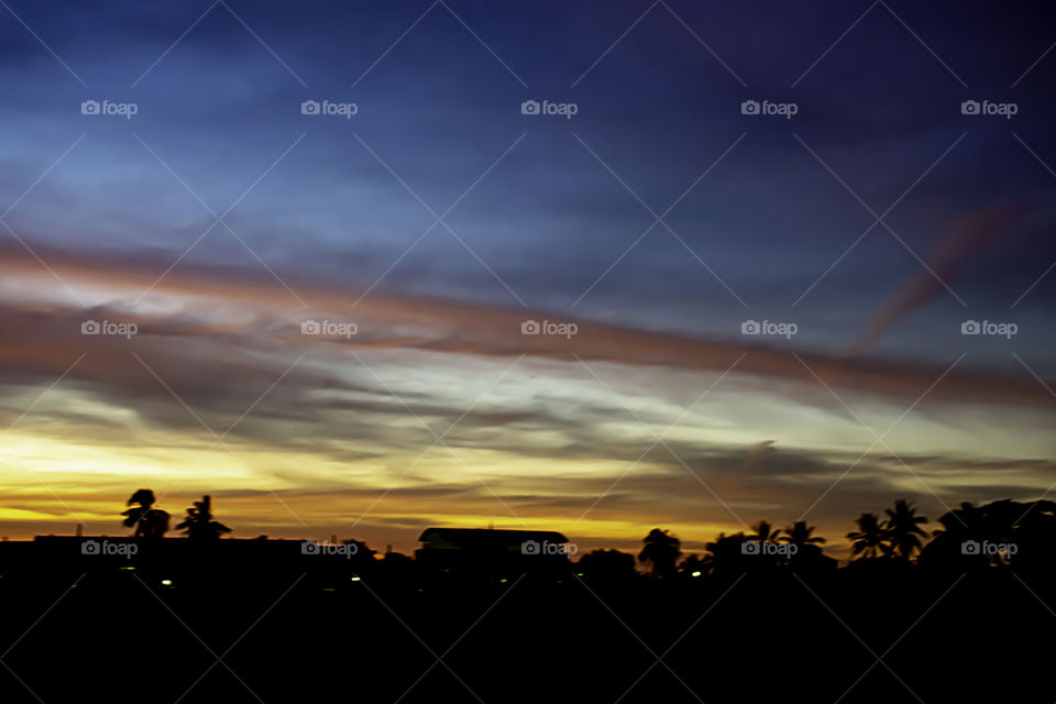 Beautiful light of Sunset with clouds in the sky reflection behind the building.