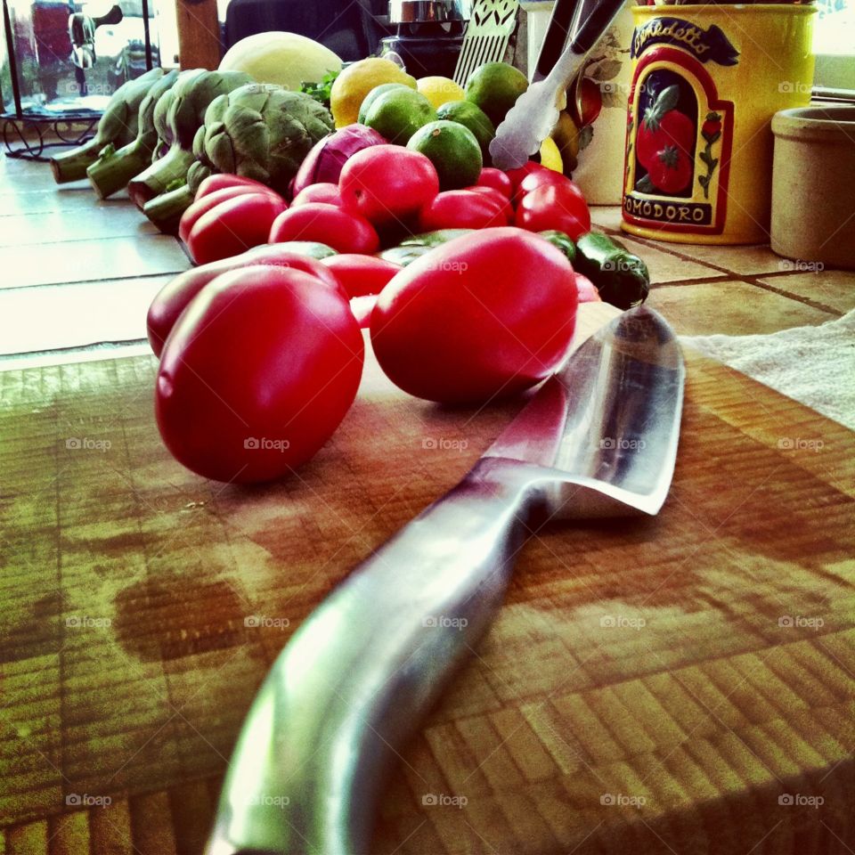 Prepping. Up close of knife and tomatoes...kitchen prep