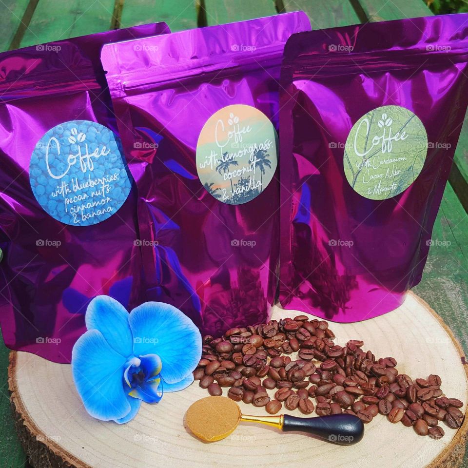 colourful presentation of homemade purple coffee bags. package design with blue orchid and coffee beans