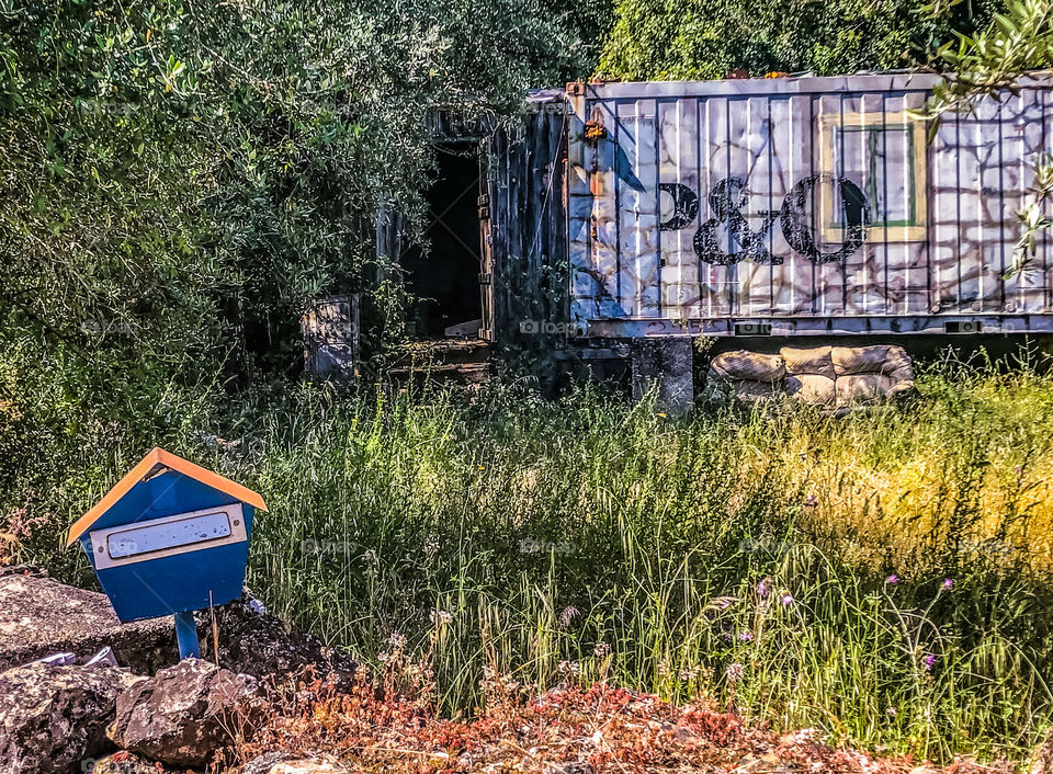 A tiny home made from an old shipping container, complete with postbox, abandoned in Central Portugal 