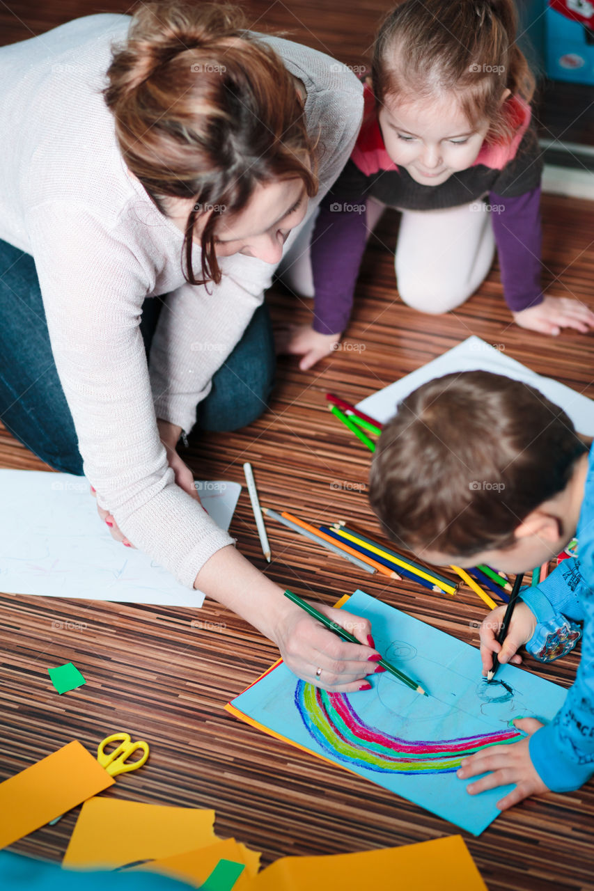 Colours of the world. Children with mom drawing using crayons