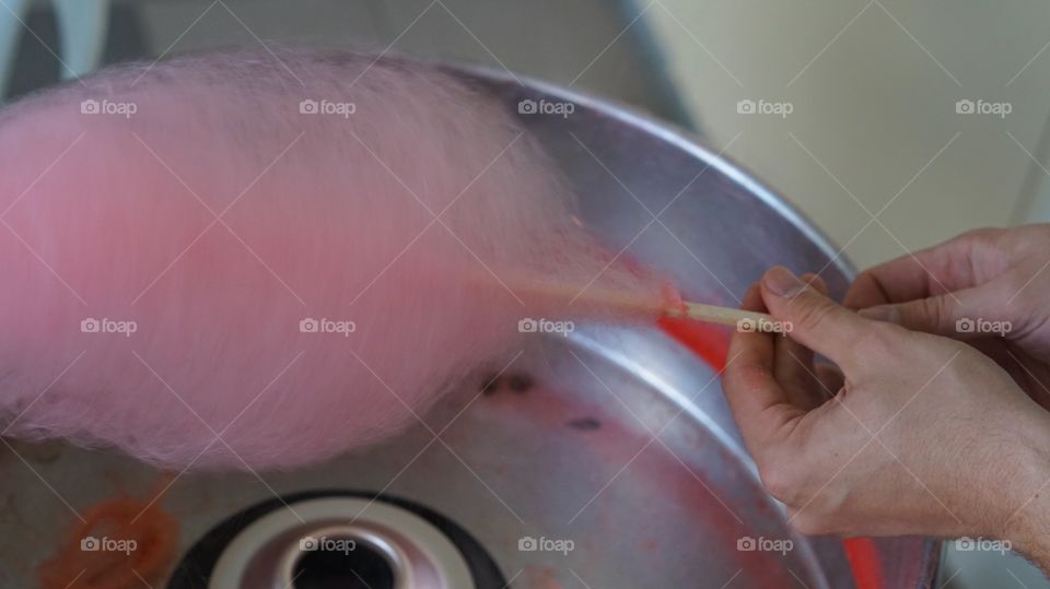 A human hand's preparing cotton candy