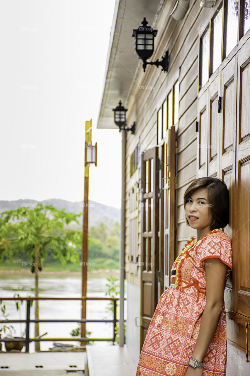 Portrait of Asean woman wearing a native of northern Thailand  background wooden wall.