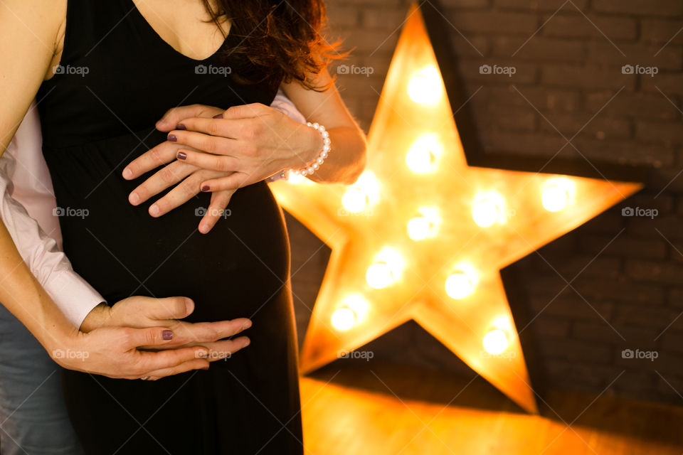 Mid section view of pregnant woman and man