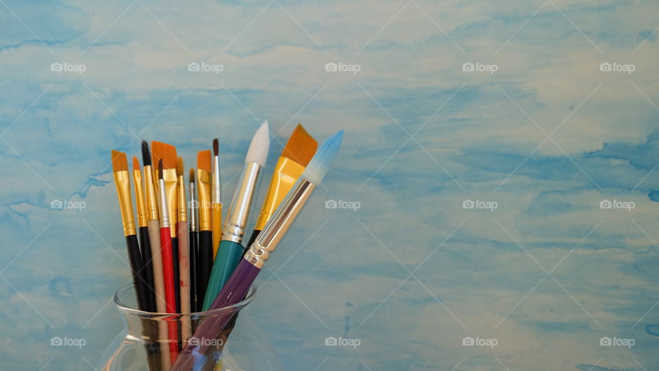 Collection of paint brushes  against a blue background