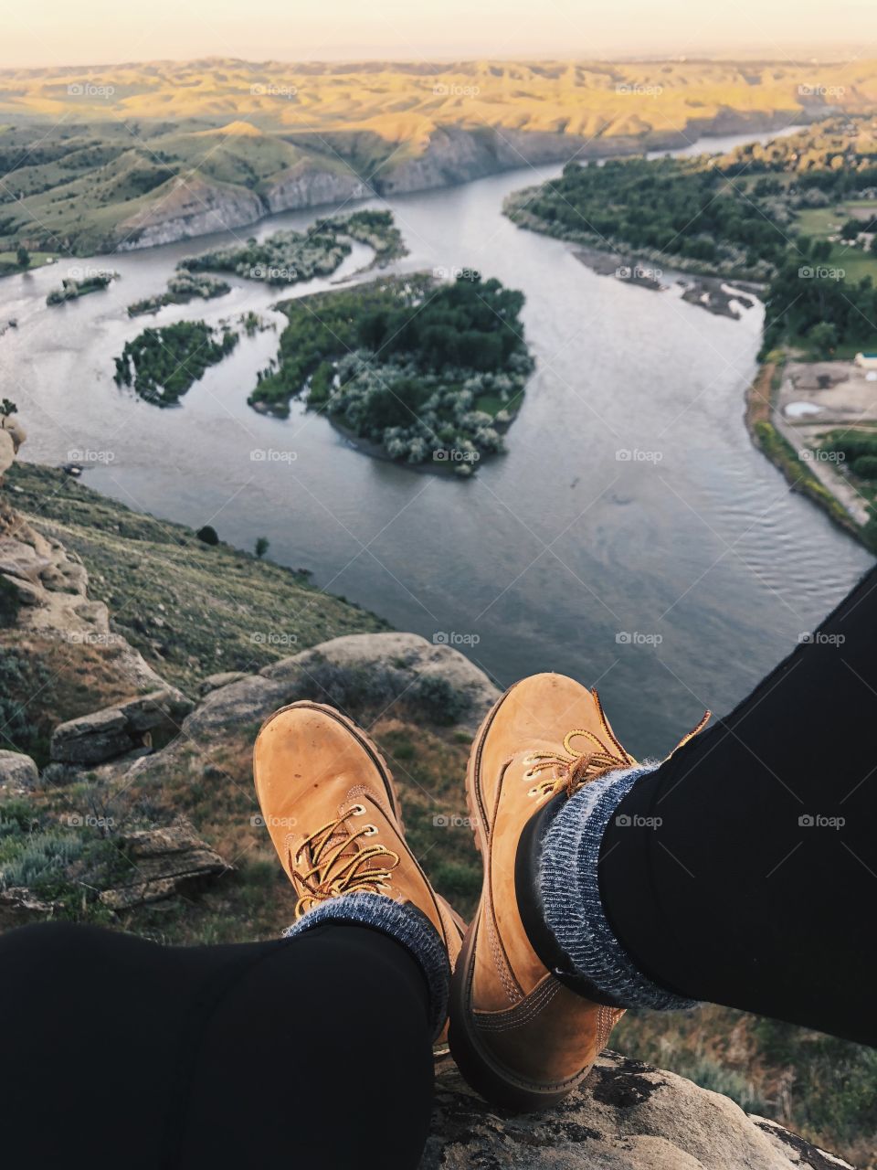 Boots hanging off ledge overlooking gorgeous Montana river. 