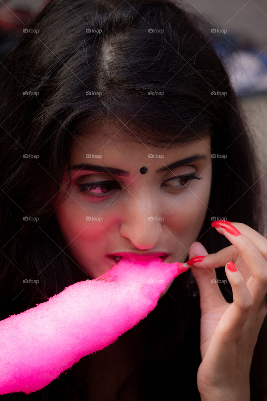 She is enjoying sweets during puja festival.