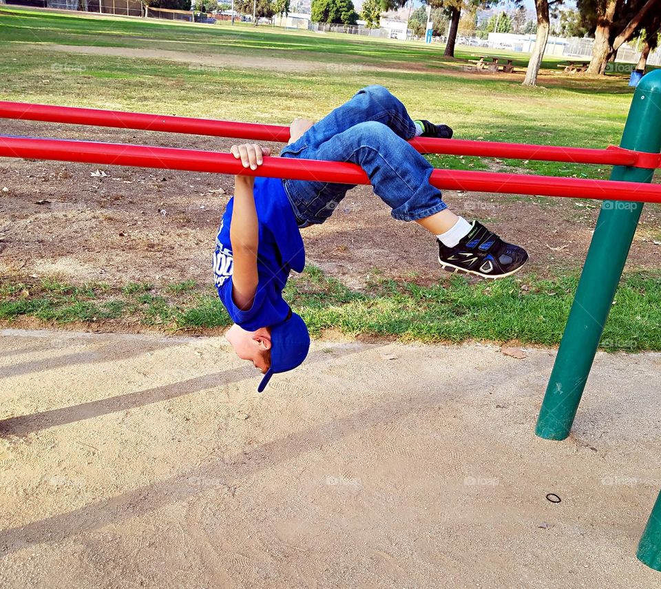 Boy upside down on the parallel bars!