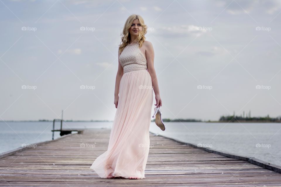 woman barefoot in beautiful dress. woman in beautiful dress standing on the deck barefoot