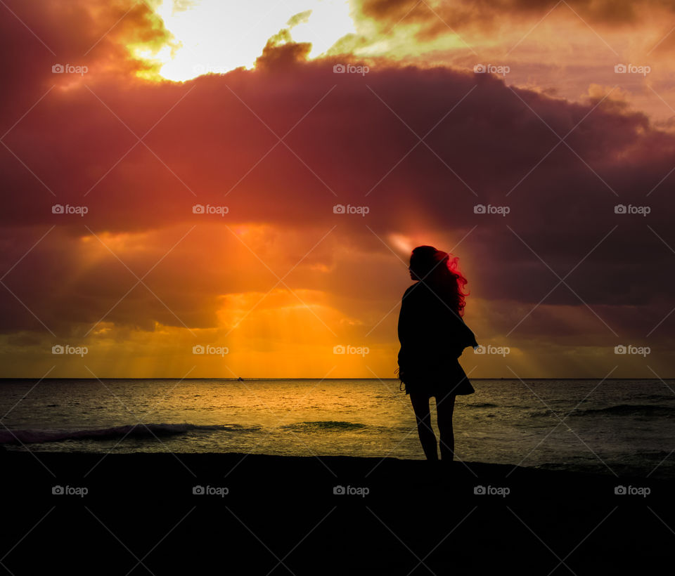 A silhouette of a girl watching sunset 