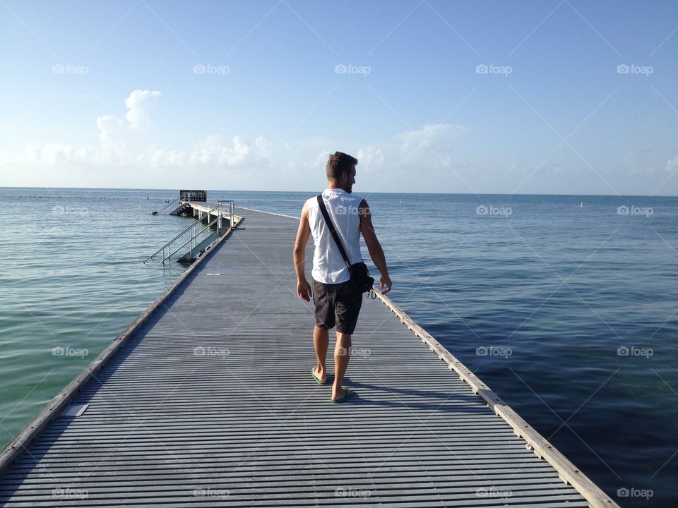 Man is walking . Beside the sea