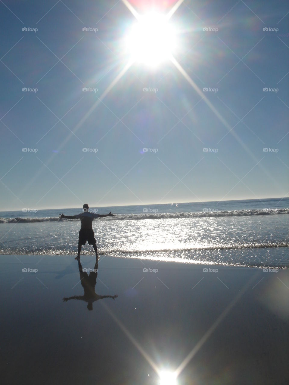 Man basking in the sun on the shore of the Pacific Ocean in California
