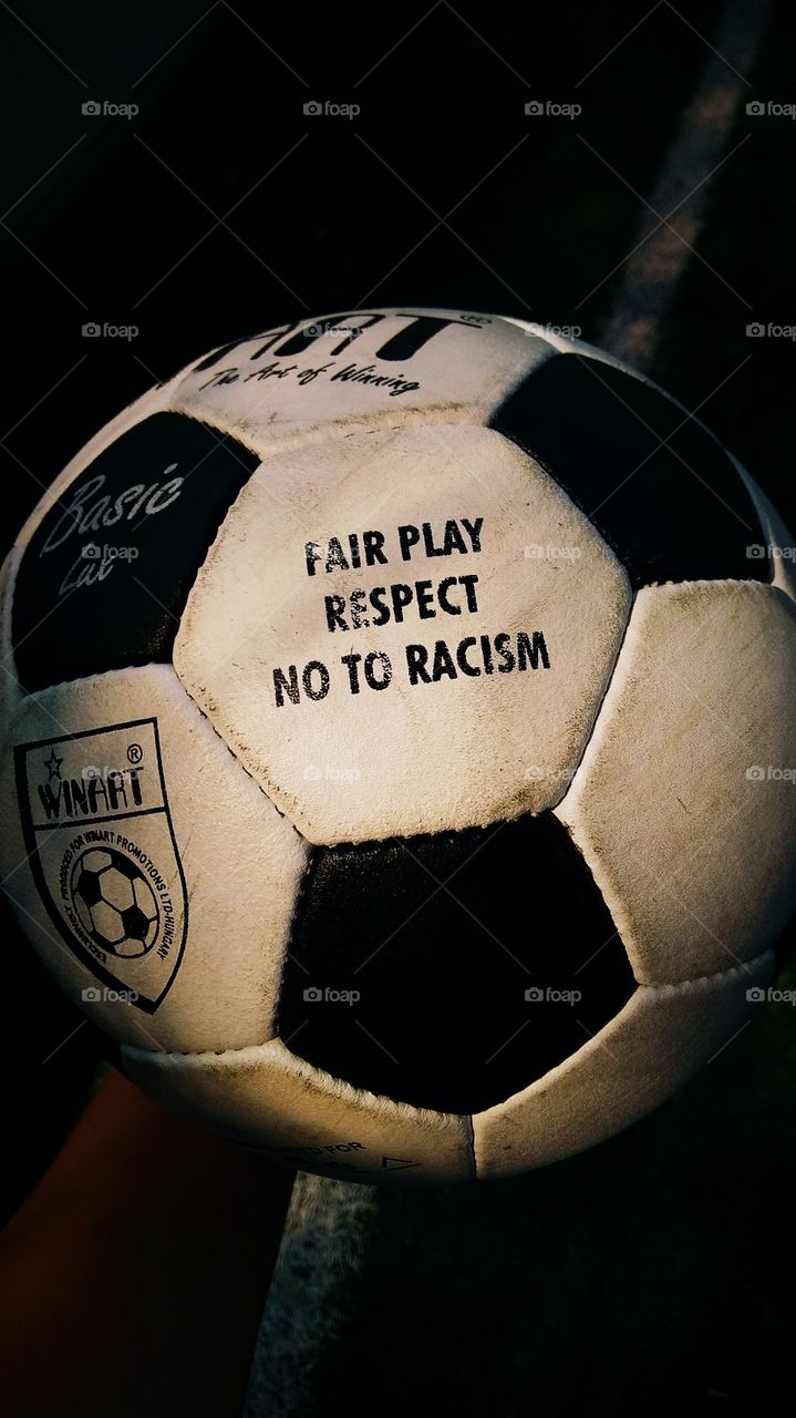 Fair play, respect, no to racism football in hand