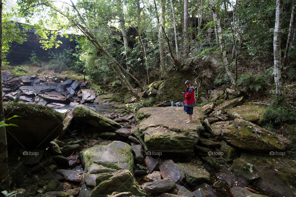 Female tourist in the waterfall rock