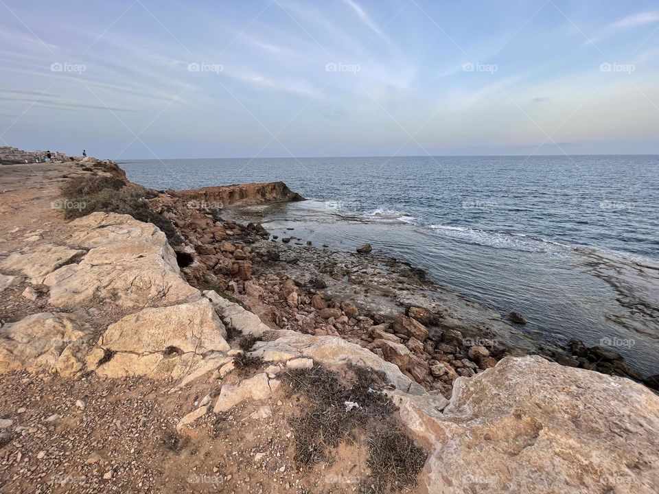 Rocky beach promenade with local flora towards sunset, Torrevieja Spain 