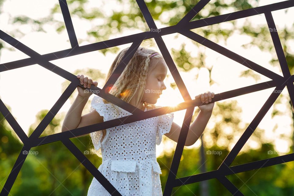 Portrait of little Caucasian girl on sunset 