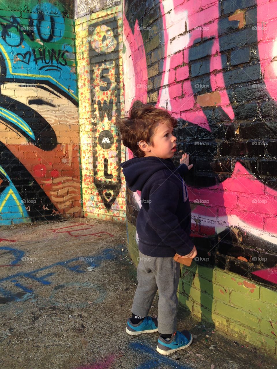 A young boy looking at street art