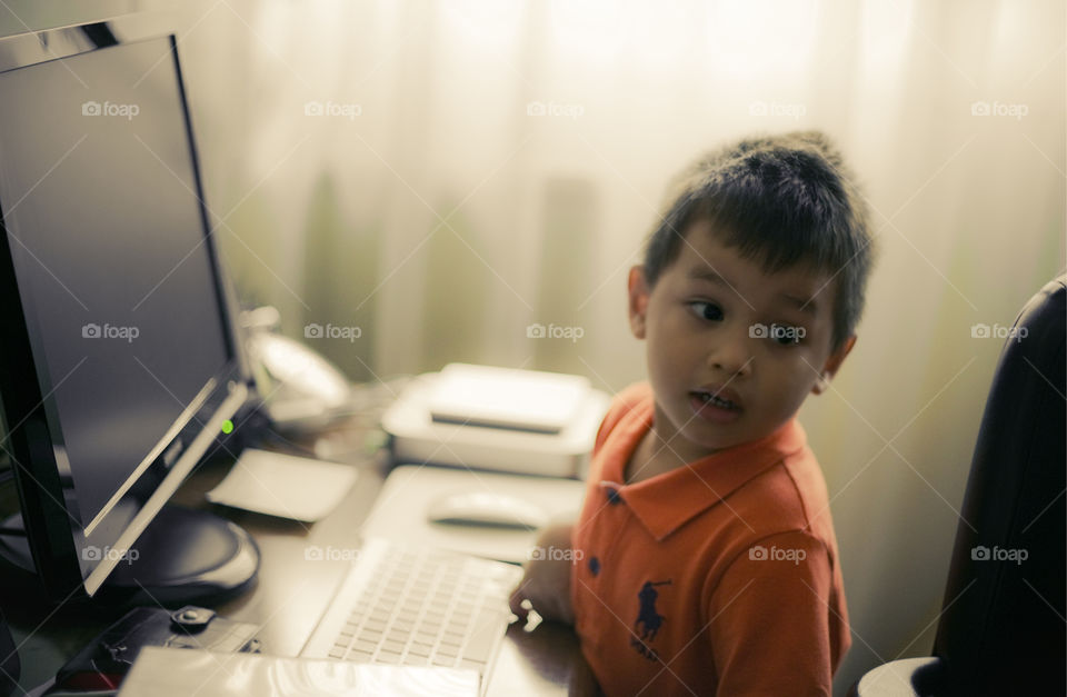 kid at an office desk in front of a computer