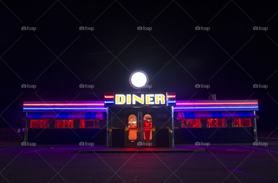 A brightly lit American Diner with neon lights at night