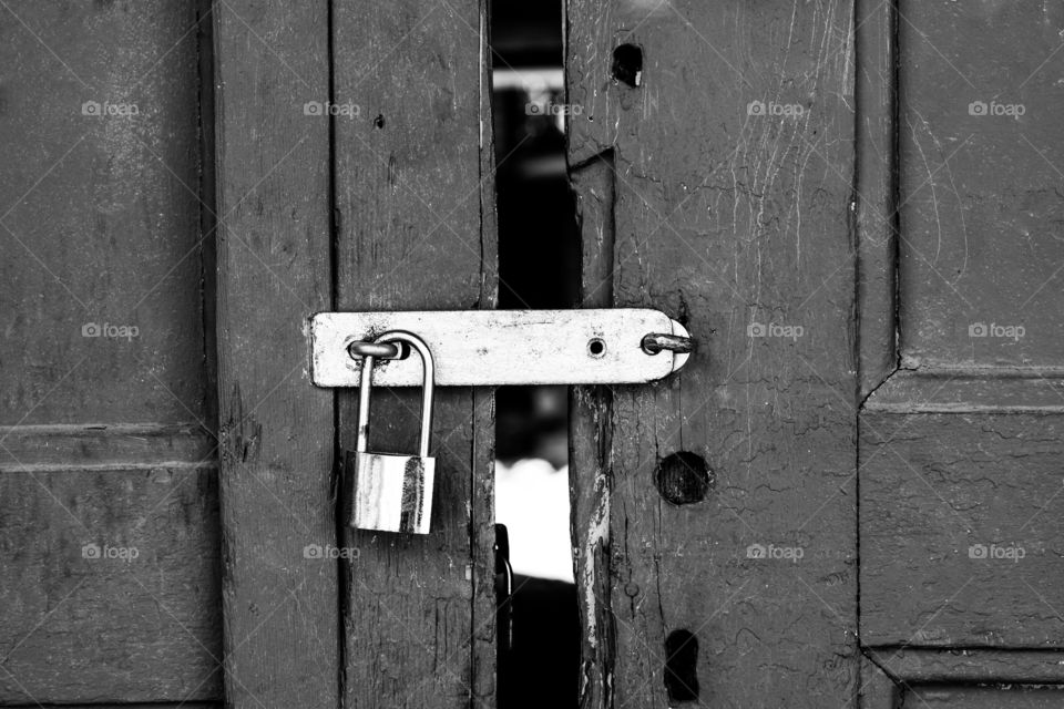 Large padlock on wooden door. Padlock was photographed in city center