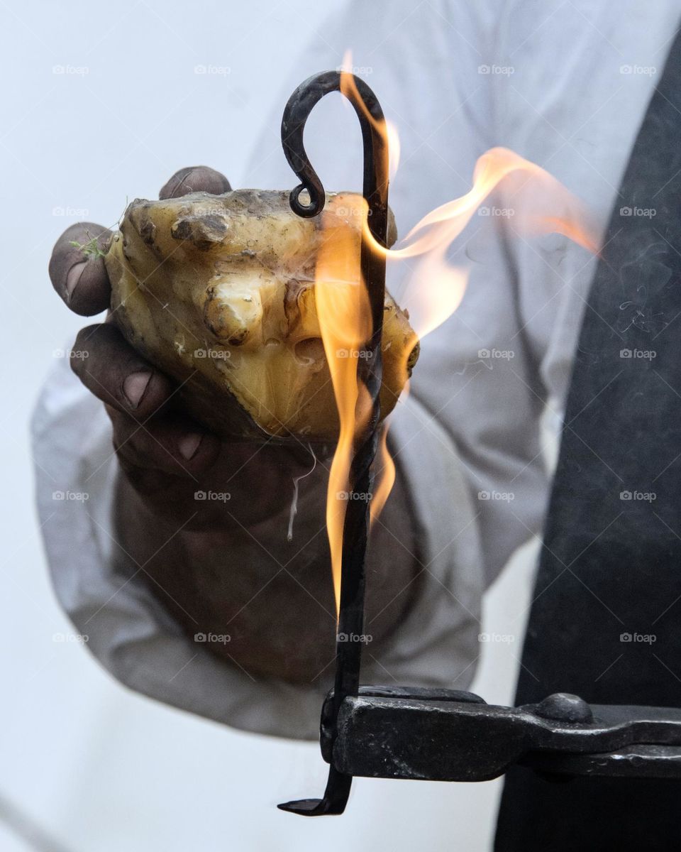 Blacksmith adding beeswax to hot metal