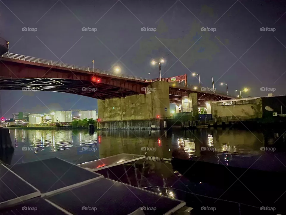 „Newtown Creek“ is an ocean inlet of the „East River“. Here by the „Pulaski Bridge“ quite a few boats are tied up and tonight on „July 4th, 2022“ the fireworks were launched from nearby here to celebrate America‘s independence. Hypnotic Productions