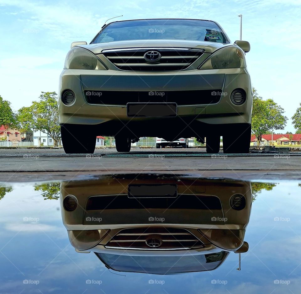 Car mirroring after rain with blue sky