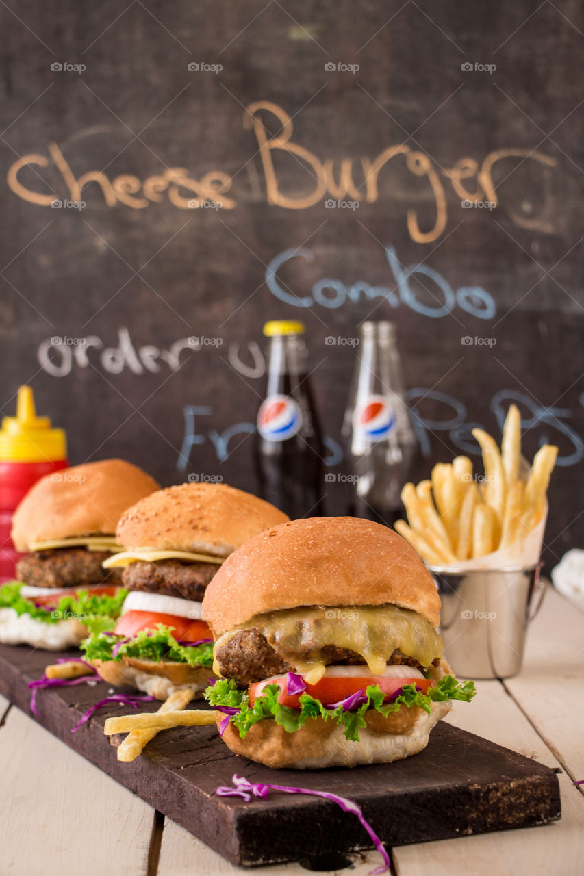 Cheese burger sandwiches, fries and Pepsi