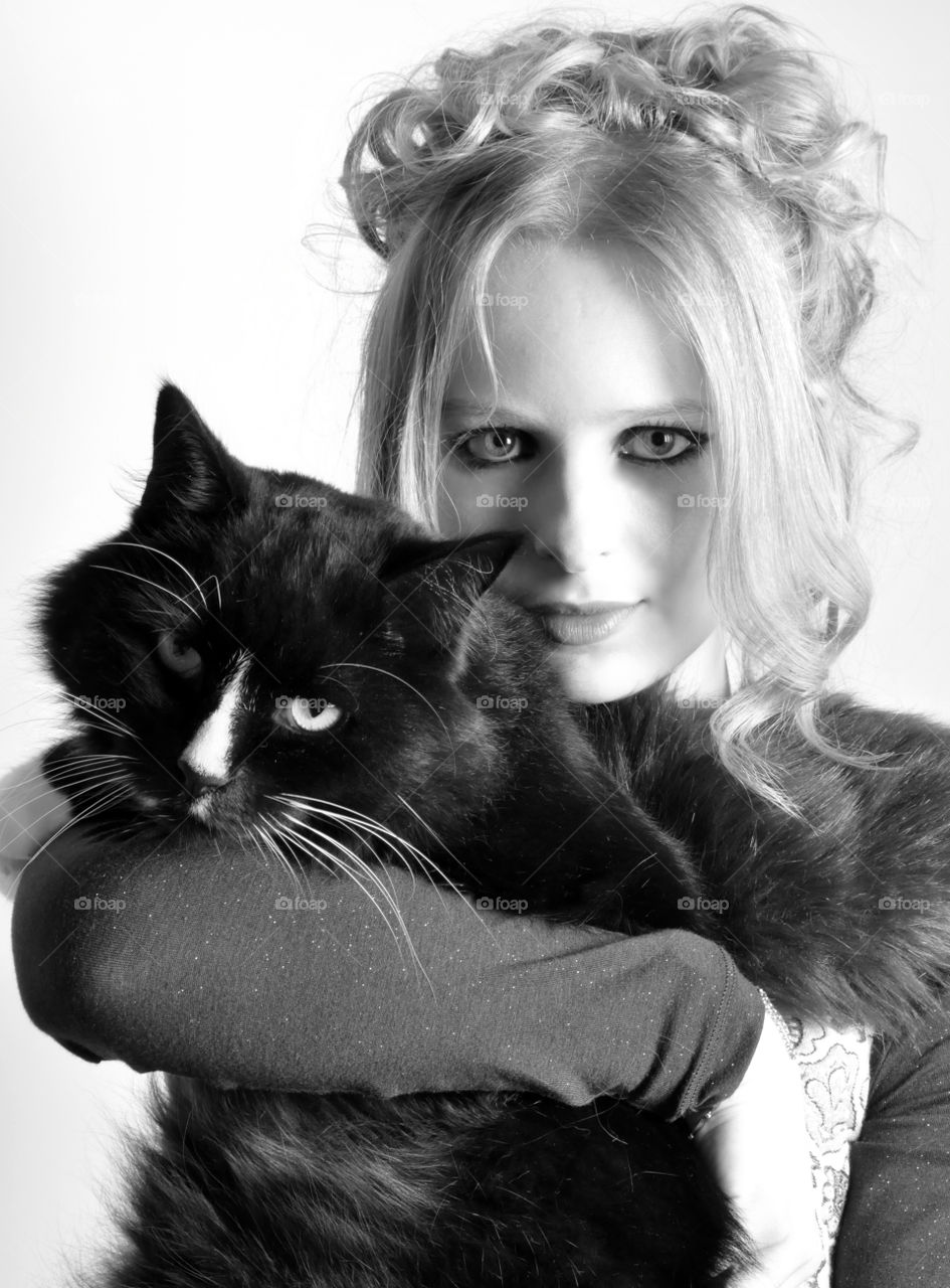 Beautiful young woman holding black cat