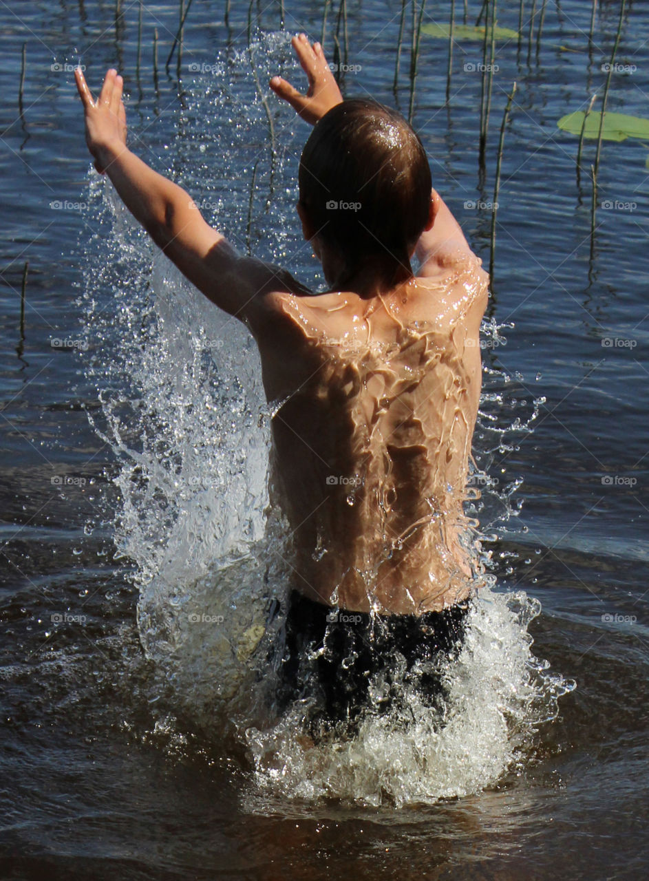 Swimming in a summer lake. A boy swimming in a lake in Finland during summer heat