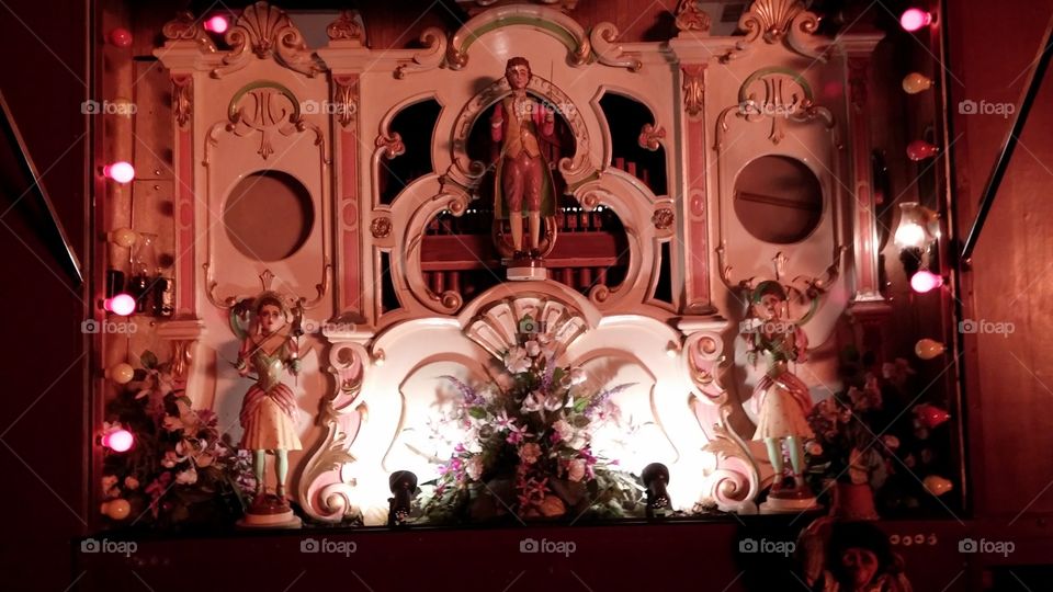 Old vintage marionette-style organ on display amongst the light of the bonfire beyond. 