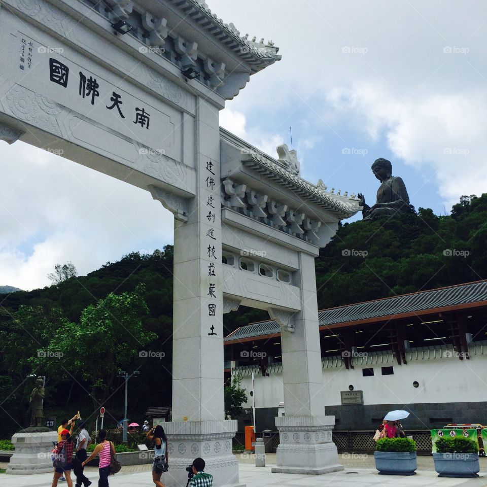 Chinese Pagoda arch with Big Buddha (Tian Tan Buddha/天壇大佛) in background. Lantau Island, Hong Kong.
