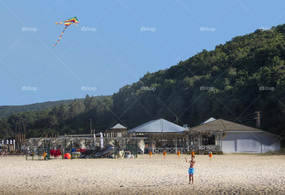 Boy holds a kite on the beach