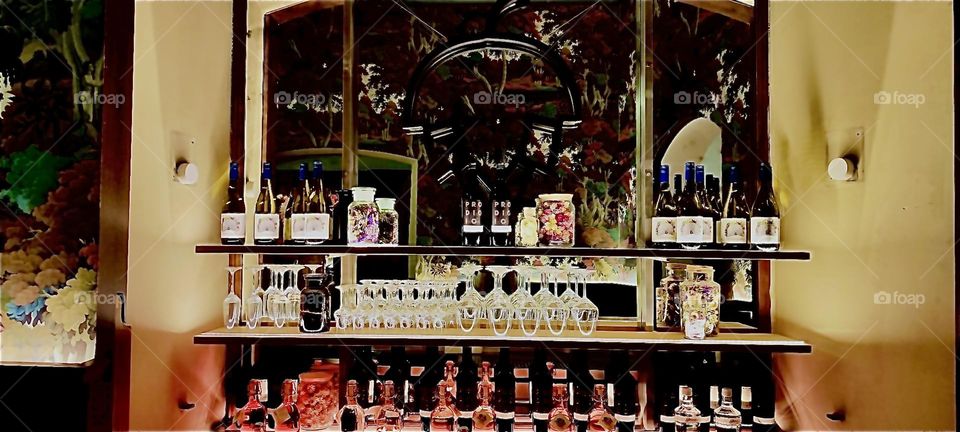 The bar at “Haus Heuport” has a variety of wines and liqueurs to offer in elegantly styled glasses that are hung upside down ready to be used. 2023. Hypnotic Productions