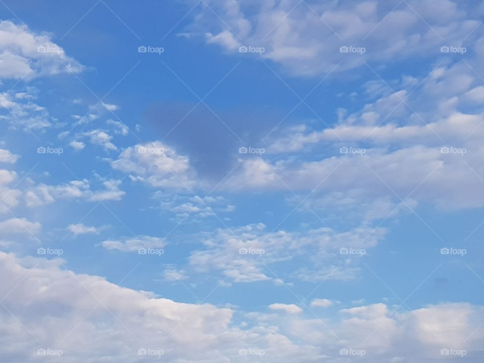 Blue morning sky, white clouds and 1 dark cloud. In the shape of a heart. My day today!