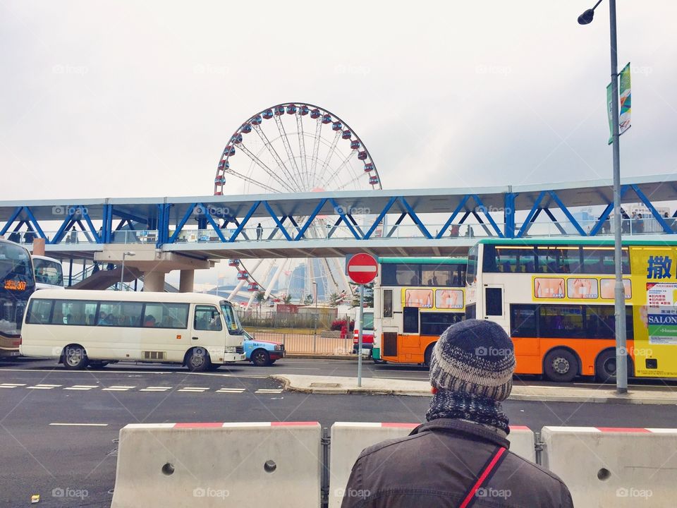 Young man looking at a Ferris Wheel in Central Hong Kong 