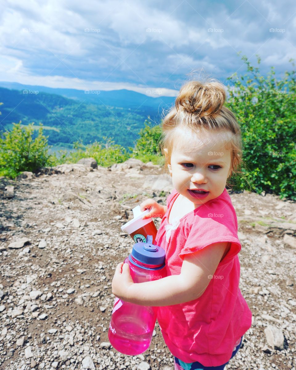 Close-up of a little girl holding water bottle in hand