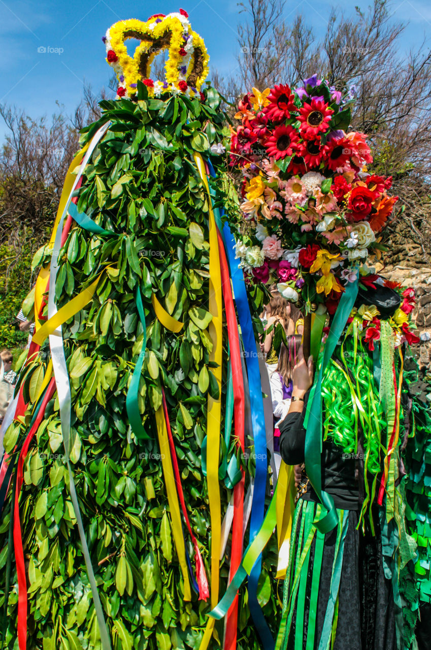 A woman carries flowers, next to “the Jack” at Hastings Traditional Jack in the Green, U.K. 2008