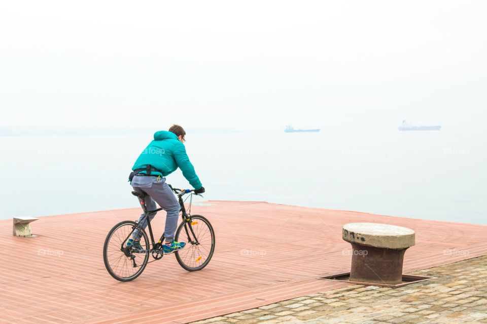 Young Man On Bike Ride On The Quay
