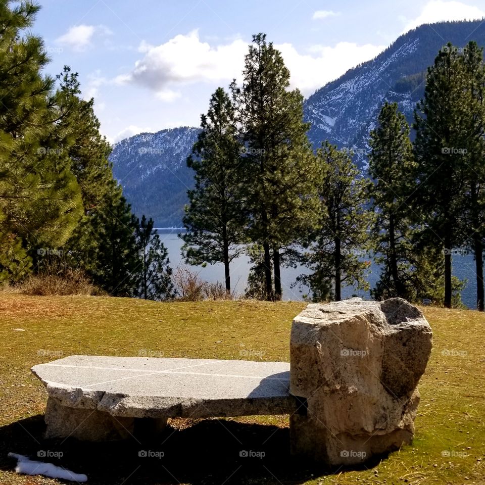 stone bench of lake and mountain with a hint of snow