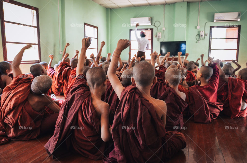Children buddhist monks learning english and singing along their theacher