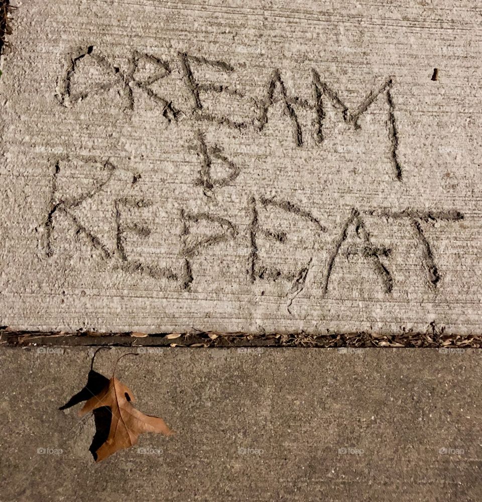 Messages scratched out to random targets on city sidewalk concrete repair areas-