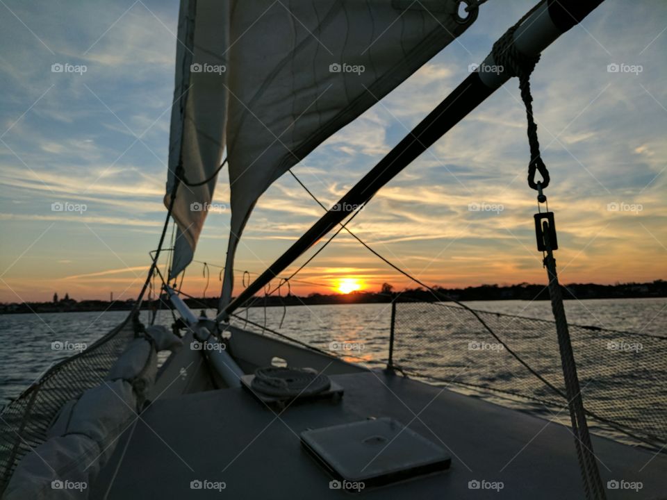sailing towards the coast and into a beautiful sunset