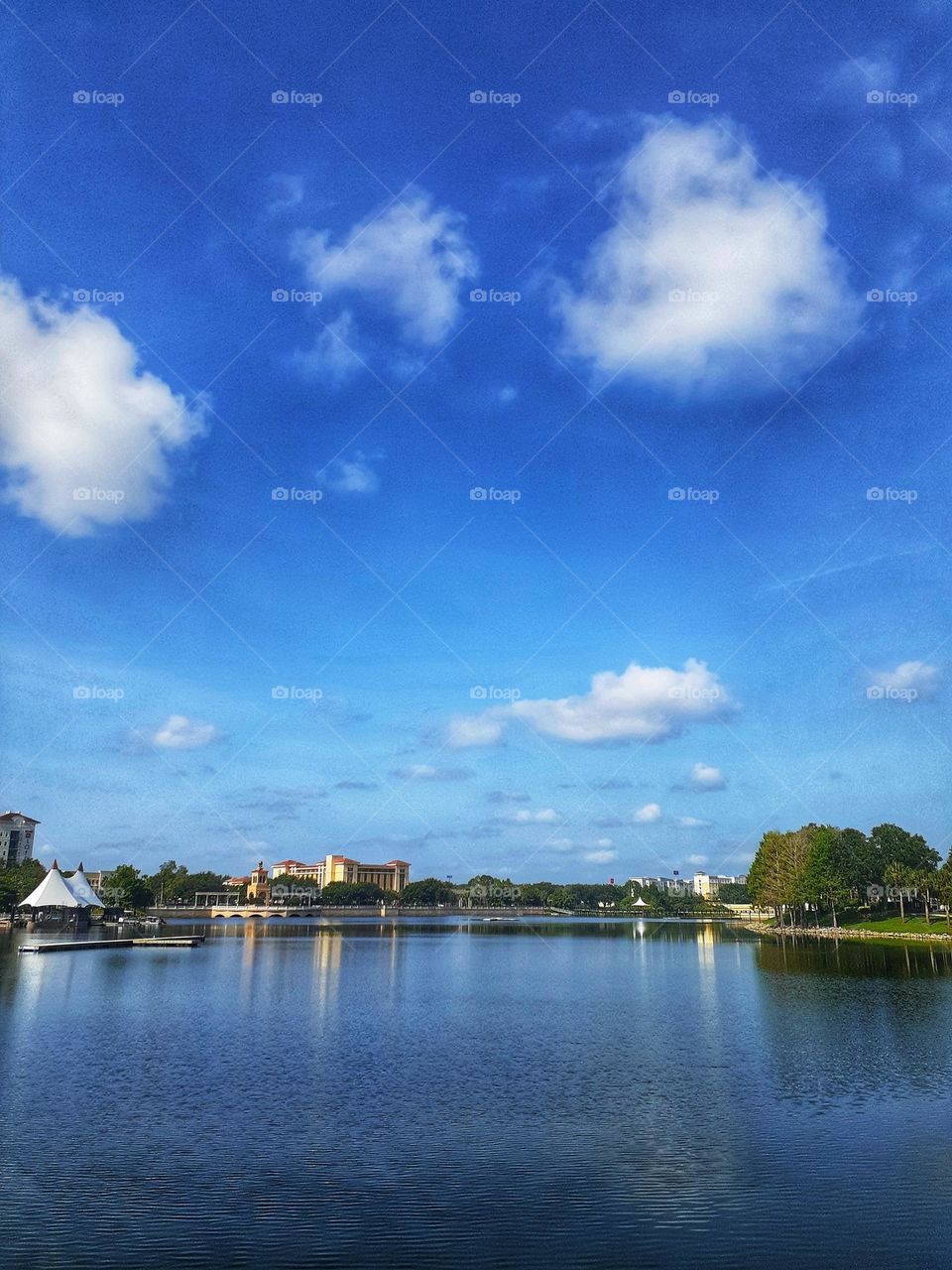 A beautiful landscape photo of the blue sky and blue water of the lake at Cranes Roost Park.